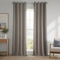 Gray curtains hanging in a room with a window, chair, and side table.