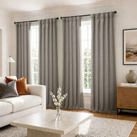 Living room with gray curtains, white sofa, and coffee table.