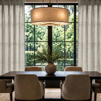 Dining room with a large wooden table, chairs, and a lamp hanging above.
