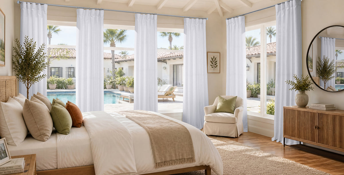 Rice White sheer curtain panels filtering natural light in a bright coastal living room with ocean views and French doors.