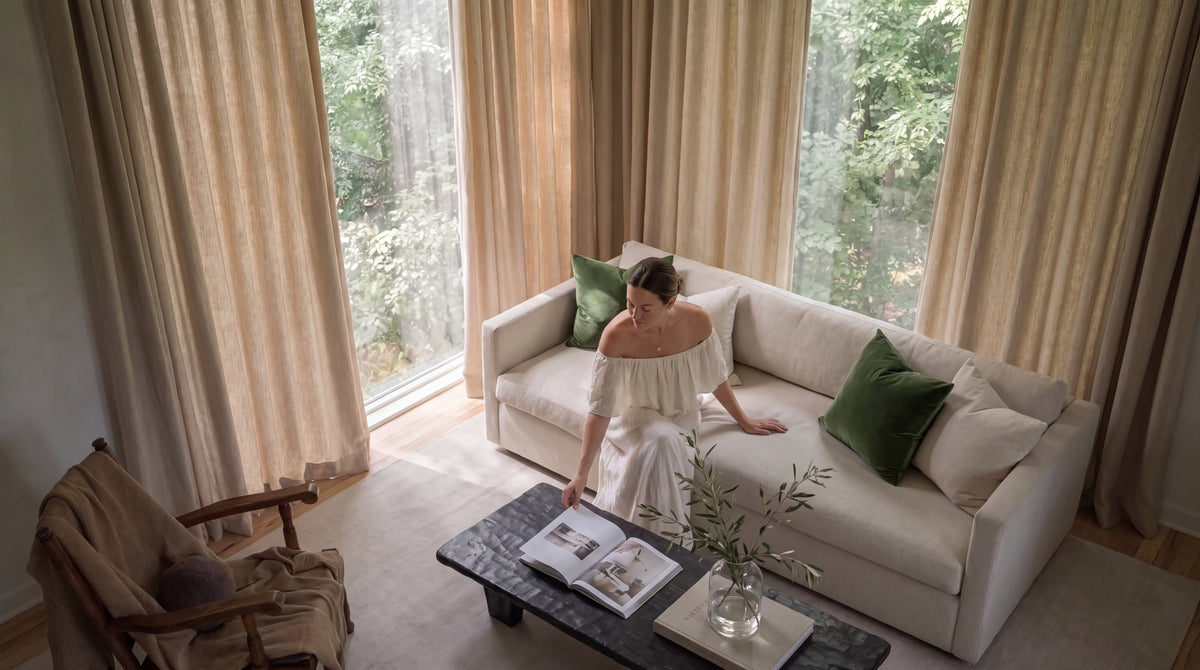 Mauve velvet curtains frame tall arched windows in an elegant bedroom with soft neutral furnishings and blush accents.