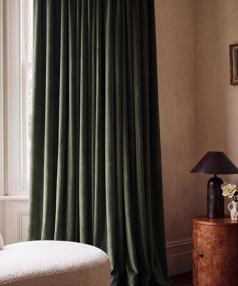 Hunter Green Velvet: Hunter green velvet curtains bring rich color and luxurious texture to a sophisticated bedroom with warm wood details.