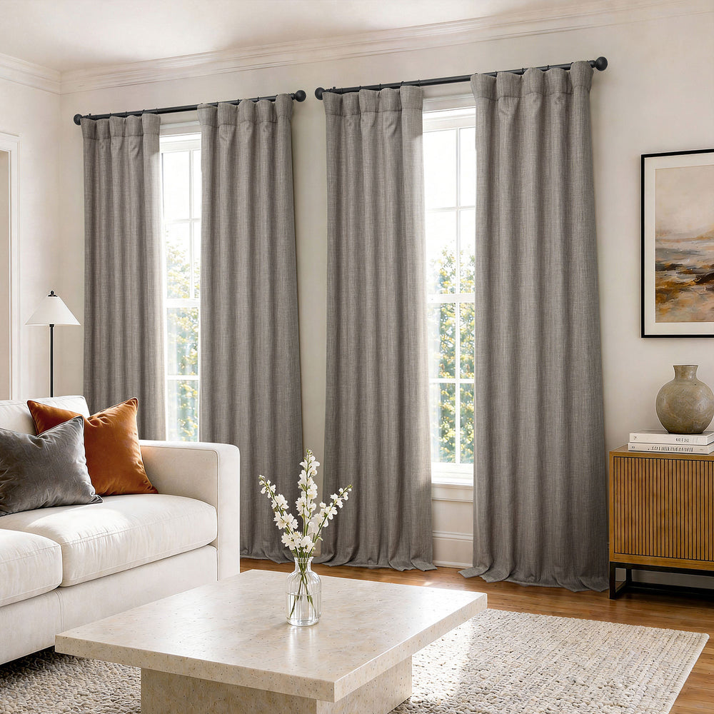 Living room with gray curtains, white sofa, and coffee table.
