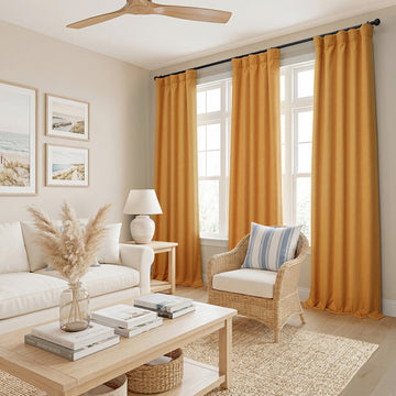 Living room with yellow curtains, white sofa, and wooden coffee table.