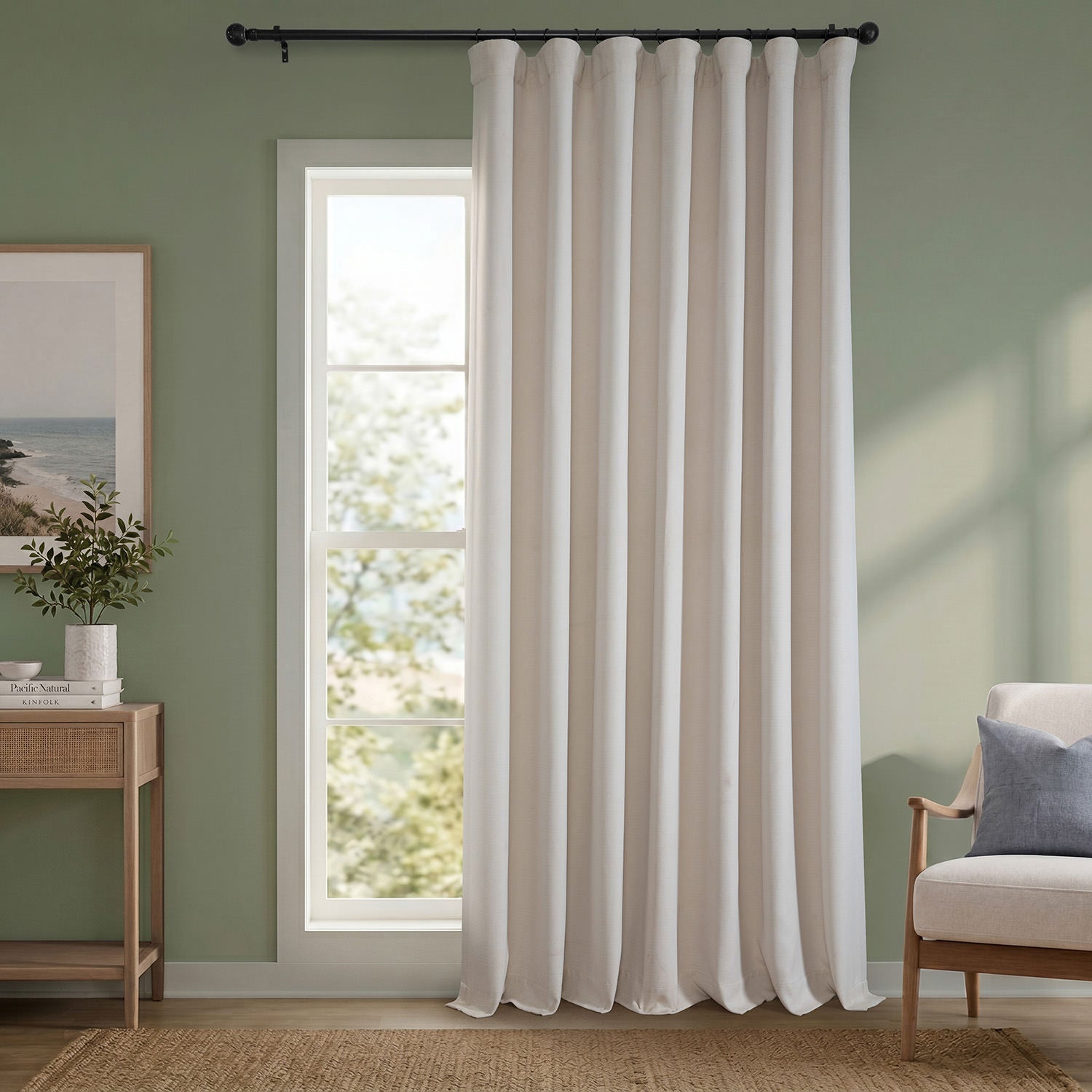 White curtain hanging in a room with a green wall, a small table with decor items, and a chair.
