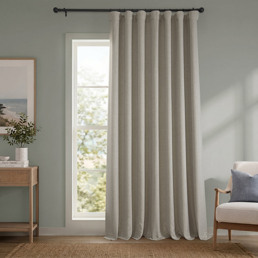 Beige curtain hanging in a room with a window and furniture.