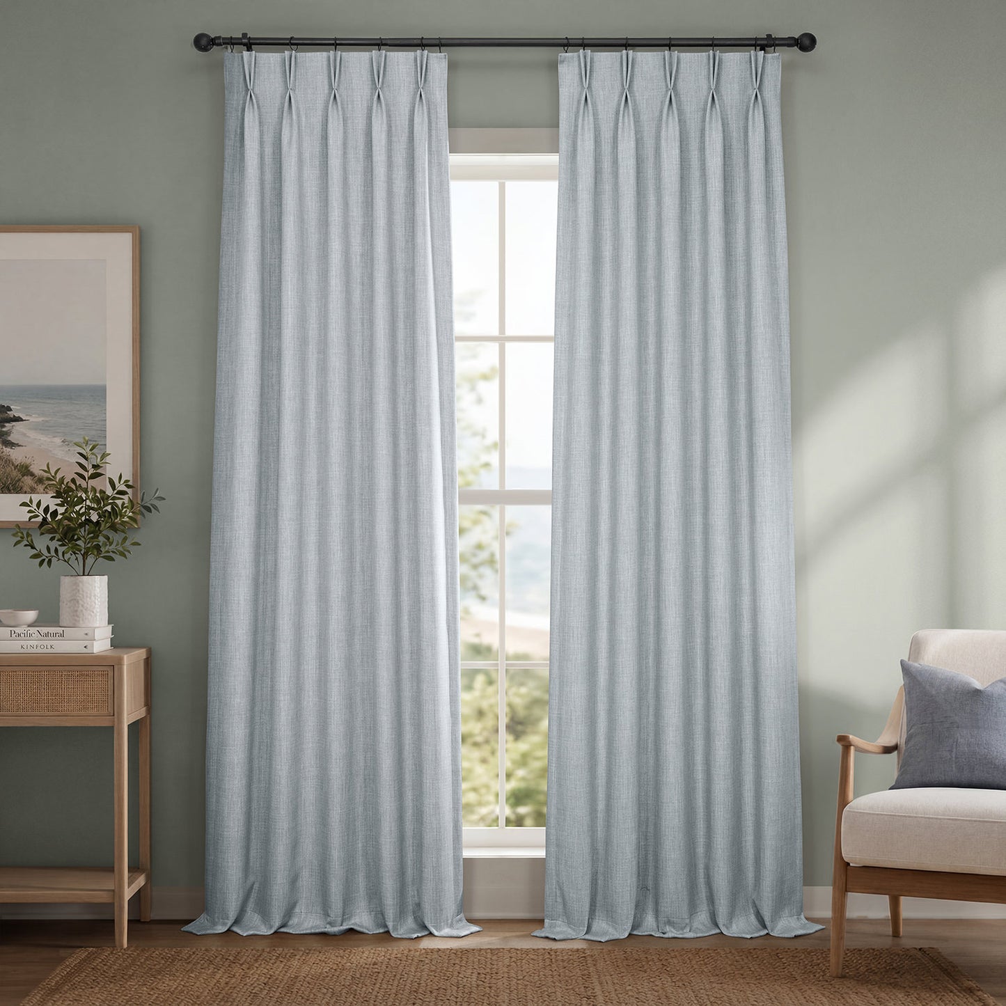 Light blue curtains hanging in a room with a window, chair, and side table.