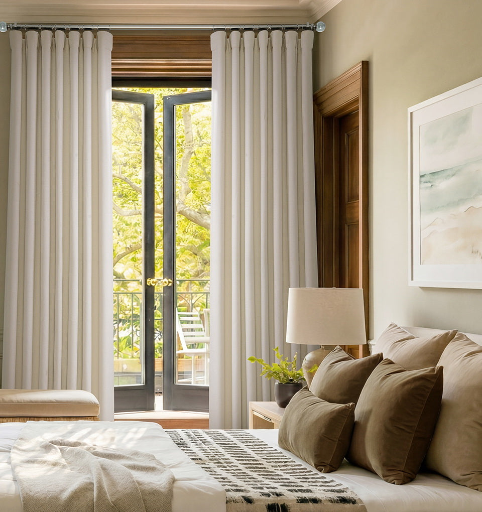 Birch curtains hanging over glass patio doors in a cozy bedroom with neutral bedding and wood trim.