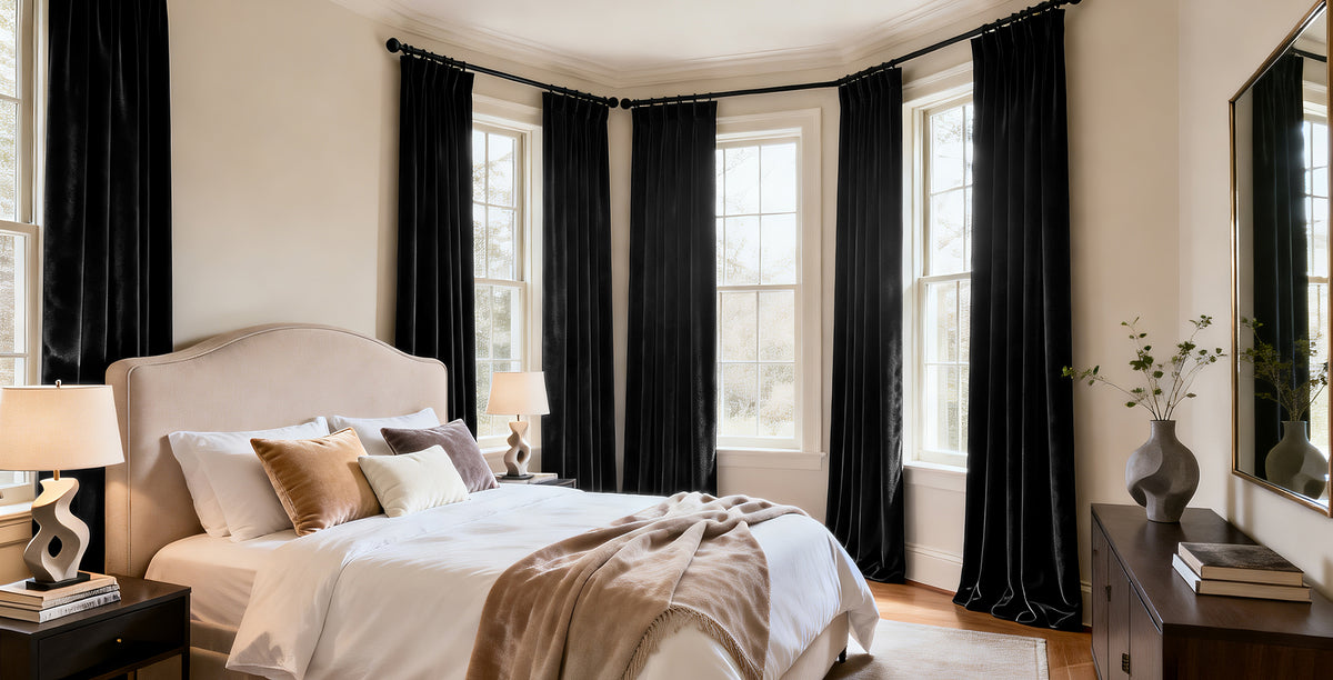 Black Heritage Plush Velvet custom curtain panels framing bedroom windows with a rich velvet texture and elegant floor-length drape.