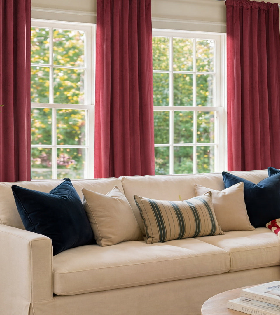 Burgundy curtains framing living room windows with a white sofa, fireplace, and patriotic décor.