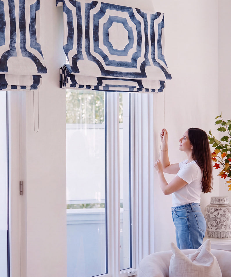 Arabesque Blue: Blue and ivory patterned Roman shades add an elegant decorative touch to three windows above a freestanding bathtub.