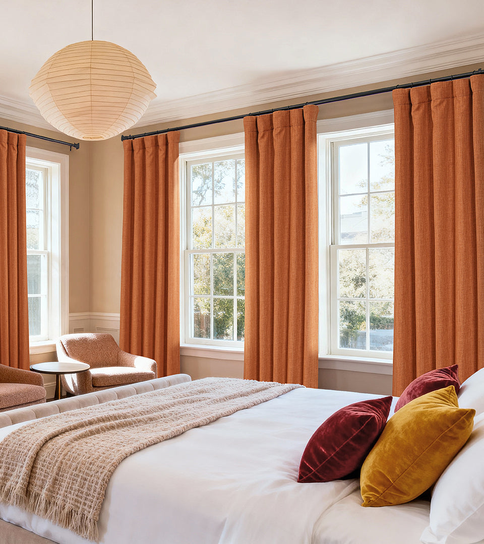 Warm desert-orange curtains bring an inviting, sun-kissed richness to this bright and cozy bedroom.
