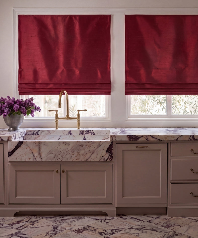 Ruby Faux Silk: Rich ruby red Roman shades frame three bedroom windows, complementing warm autumn-inspired bedding and décor.