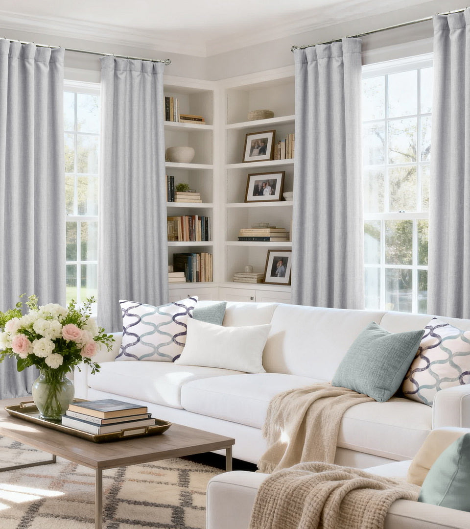Heather Grey custom curtains framing tall living room windows with a white sofa, built-in shelves, and fireplace.