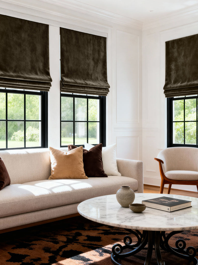 Java Signature Velvet: Rich brown velvet Roman shades add warmth and contrast to black-framed windows in an elegant, light-filled living room.