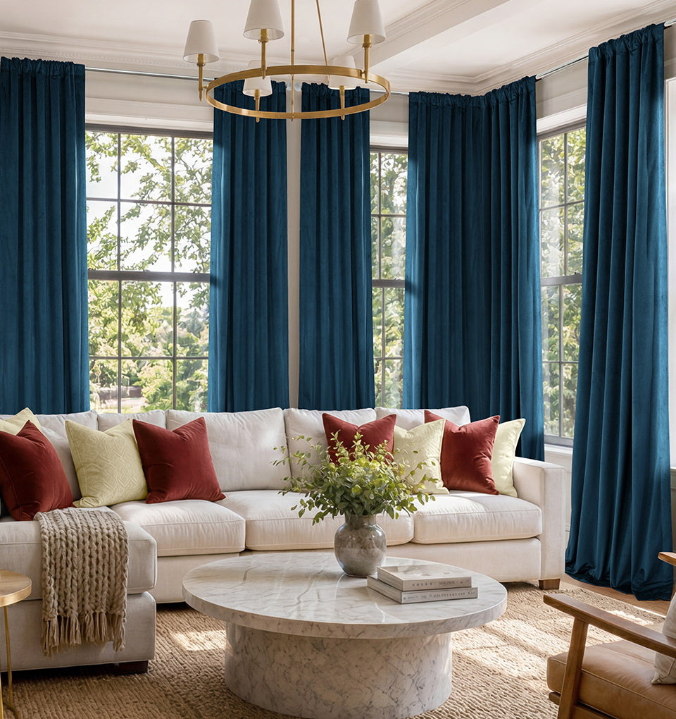 Midnight Blue curtains hanging across large living room windows with a white sectional sofa and marble coffee table.
