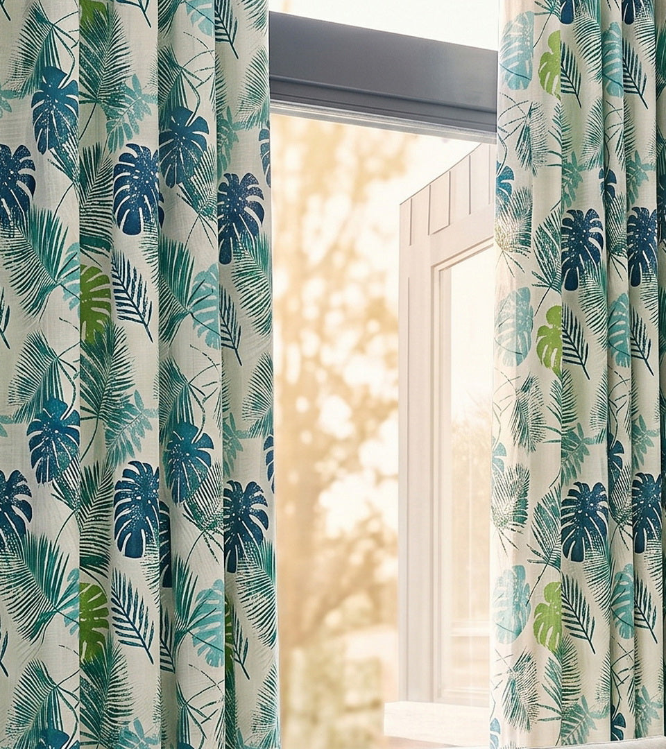 Tropical blue-and-green leaf-print curtains bring a fresh, vibrant botanical feel to the space.