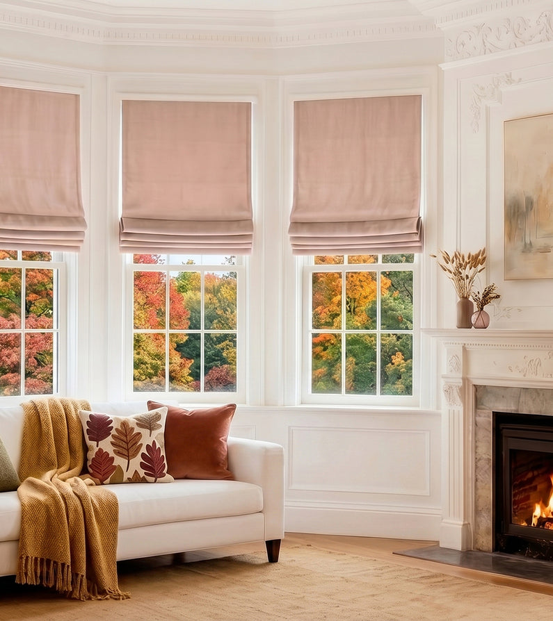 Peach Blossom: Soft blush velvet Roman shades dress three living room windows overlooking colorful fall foliage, creating a warm and elegant space.
