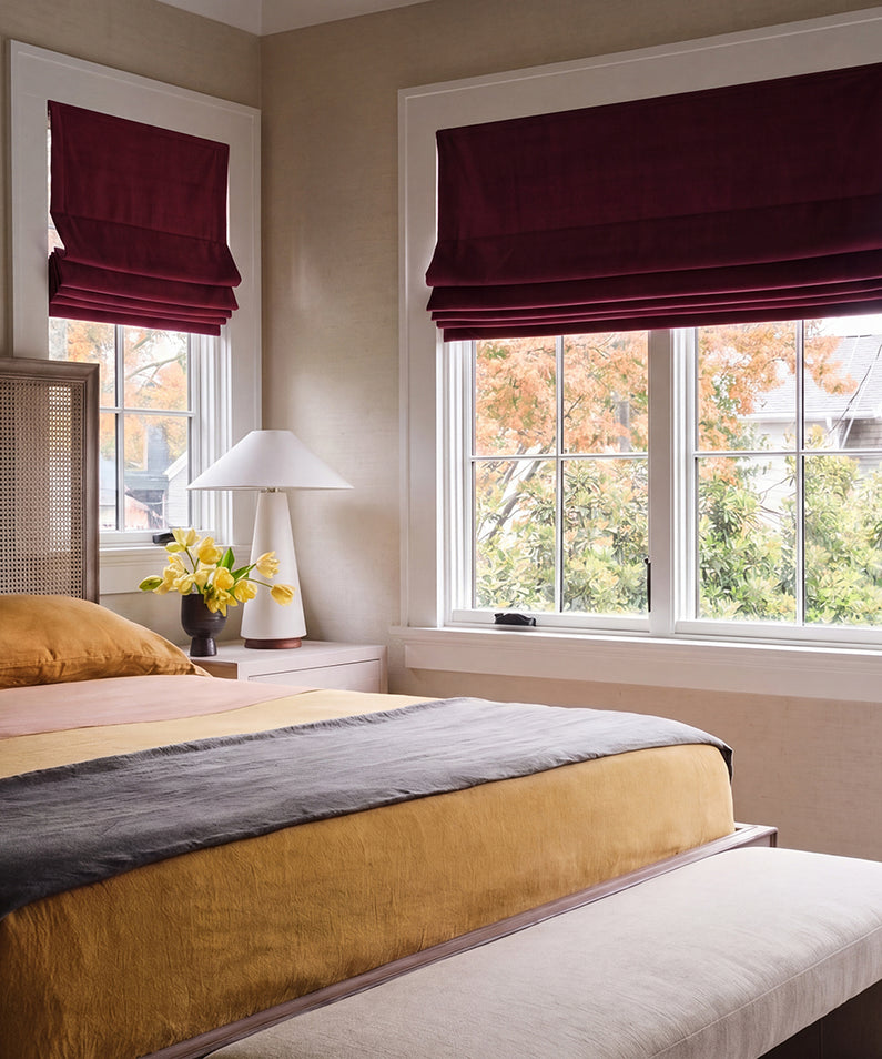 Burgundy Signature Velvet: Rich burgundy velvet Roman shades add bold color and luxurious texture to a bright bedroom.