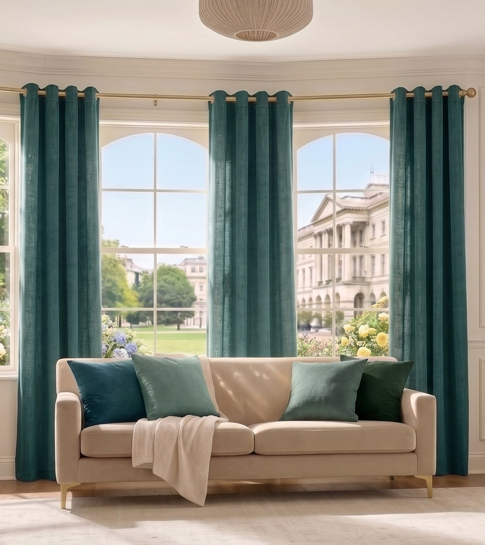 Rich teal-green curtains bring depth and refreshing color to this bright, sophisticated living room.