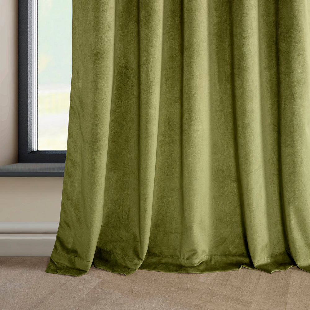 Green curtain hanging in front of a window