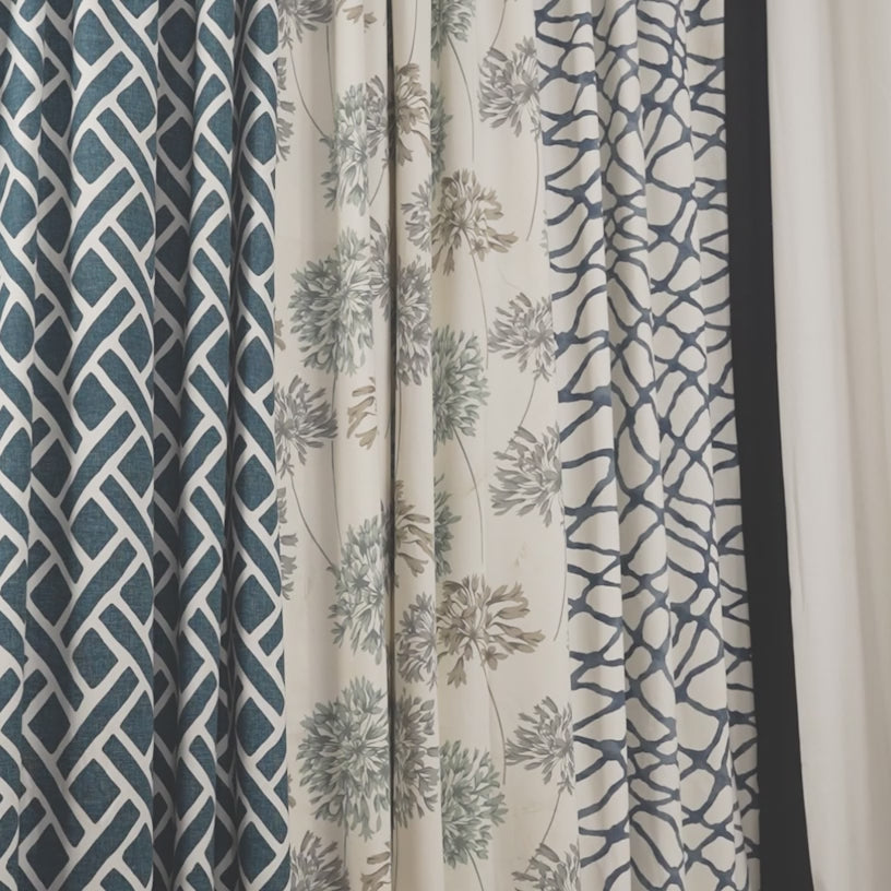 Printed cotton curtains in elegant patterns gently swaying in natural light, highlighting fabric texture, color, and movement.